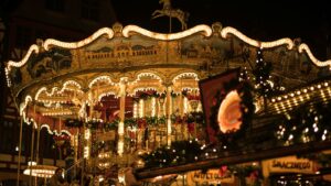 A carousel lit up at a Christmas market at night